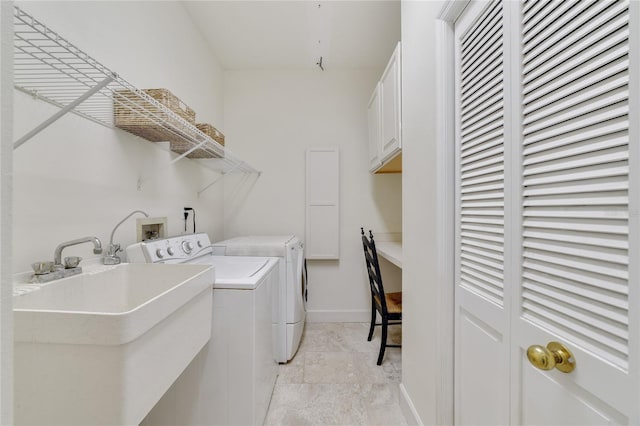 clothes washing area featuring washer and dryer, cabinet space, baseboards, and a sink