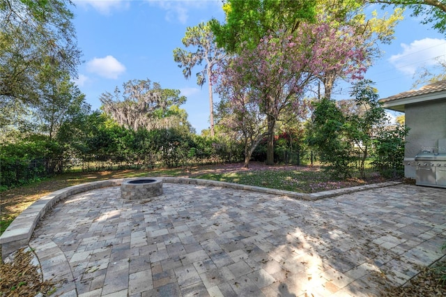 view of patio featuring a fire pit, a grill, and fence private yard