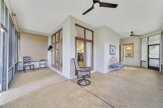 unfurnished sunroom with a ceiling fan and french doors