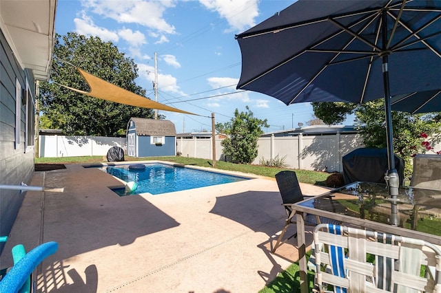 view of pool with a patio area, an outdoor structure, a storage shed, and a fenced backyard