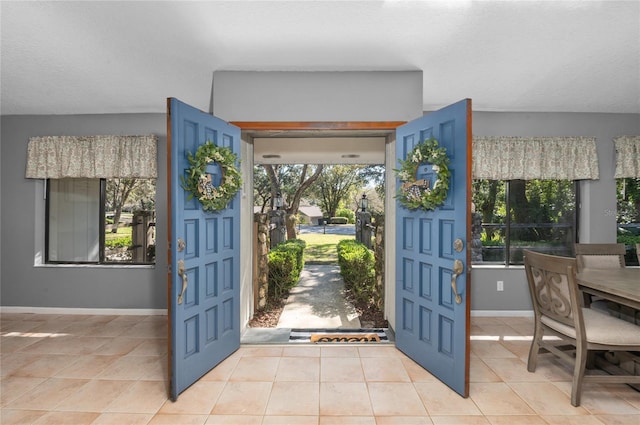 entrance foyer featuring light tile patterned floors and baseboards