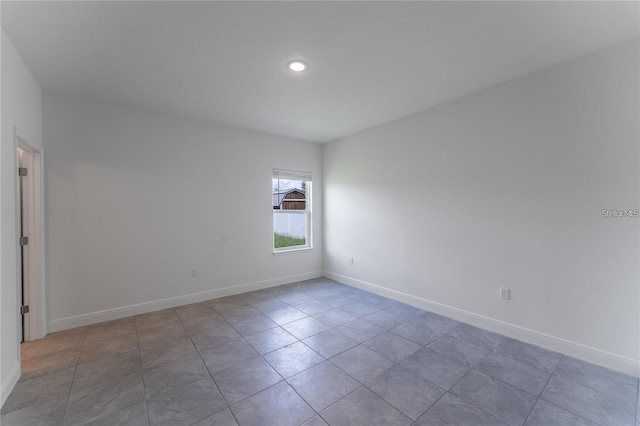 unfurnished room featuring tile patterned flooring and baseboards