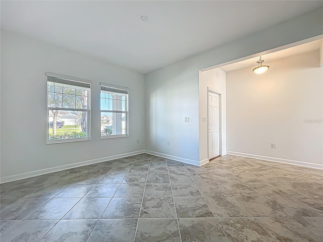 unfurnished room featuring baseboards