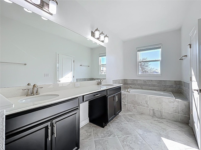 bathroom with a bath, double vanity, and a sink