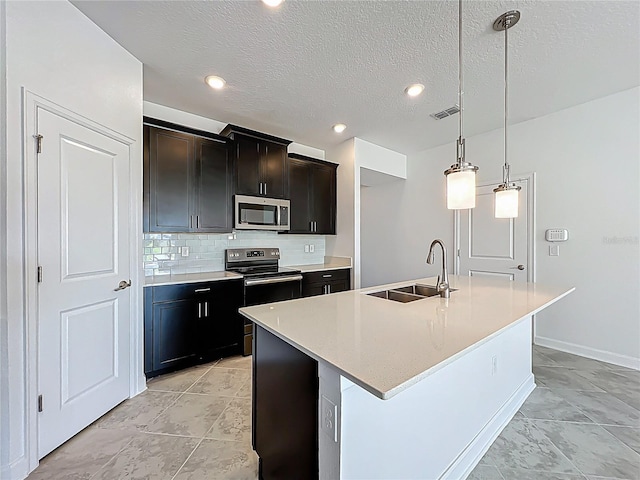 kitchen featuring visible vents, a sink, stainless steel appliances, light countertops, and decorative backsplash