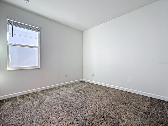 carpeted empty room with baseboards