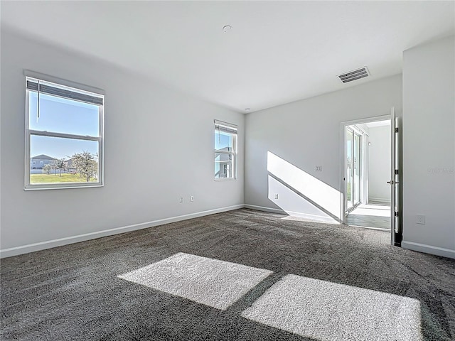 carpeted spare room with baseboards and visible vents