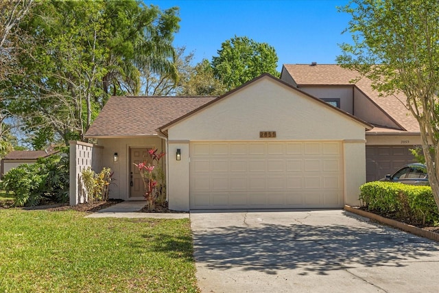 view of front of property with driveway, a shingled roof, stucco siding, a front lawn, and a garage