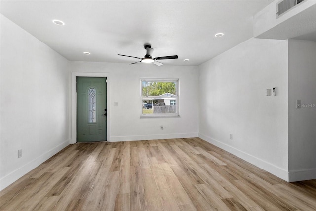 interior space with ceiling fan, visible vents, baseboards, and light wood-style flooring