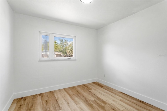 spare room with light wood-type flooring and baseboards