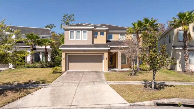 view of front facade featuring a front lawn, a garage, driveway, and stucco siding