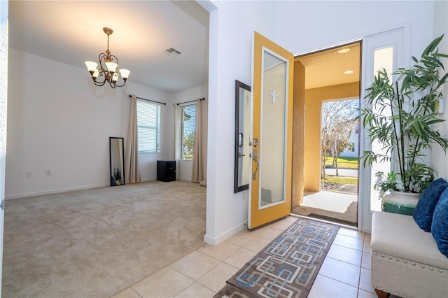 entryway with light tile patterned floors, visible vents, light carpet, and an inviting chandelier