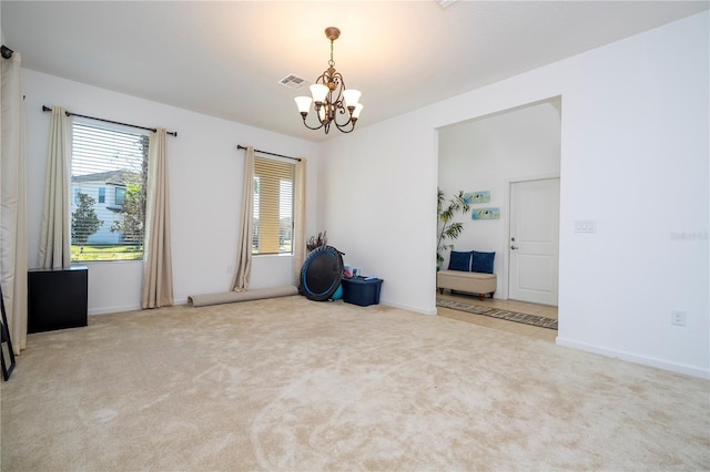 spare room featuring baseboards, visible vents, carpet floors, and an inviting chandelier