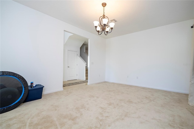 empty room with a chandelier, baseboards, and carpet