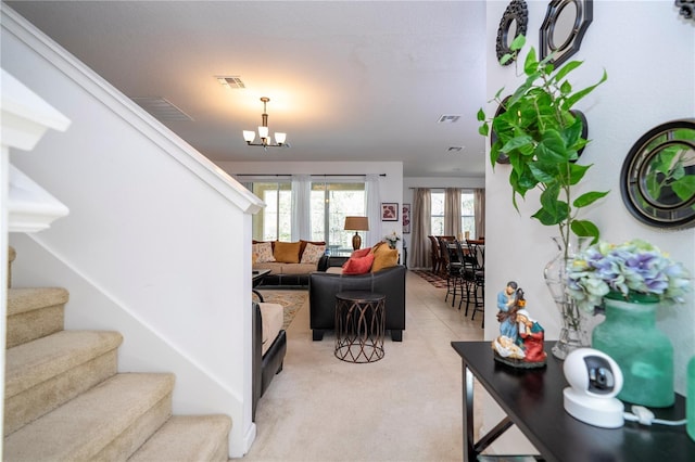 living room with visible vents, a chandelier, and stairway