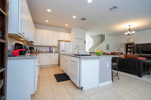 kitchen featuring visible vents, open floor plan, white dishwasher, a notable chandelier, and white cabinetry