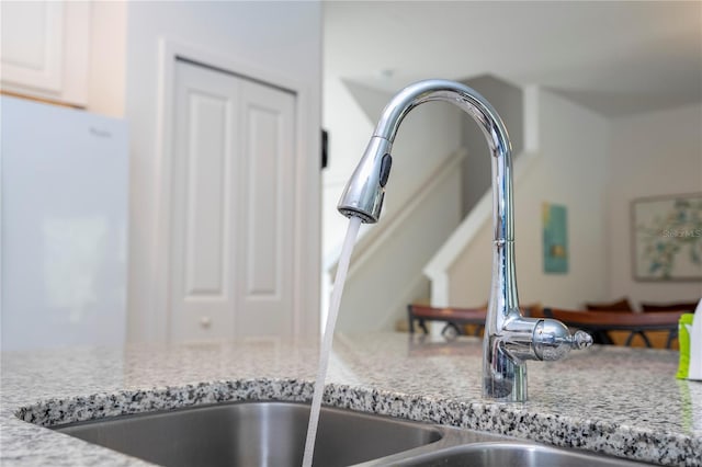 room details with light stone counters and a sink