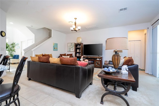 living room featuring light tile patterned floors, visible vents, a notable chandelier, and stairs