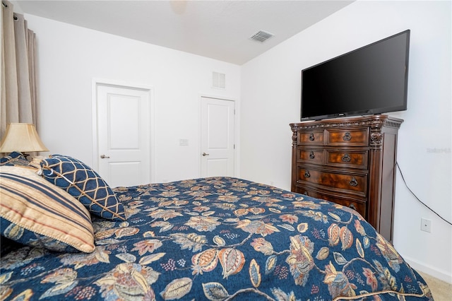 carpeted bedroom featuring visible vents