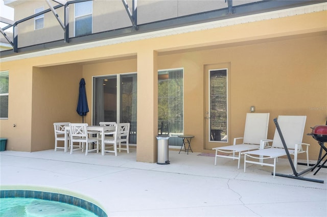 view of pool featuring glass enclosure and a patio area