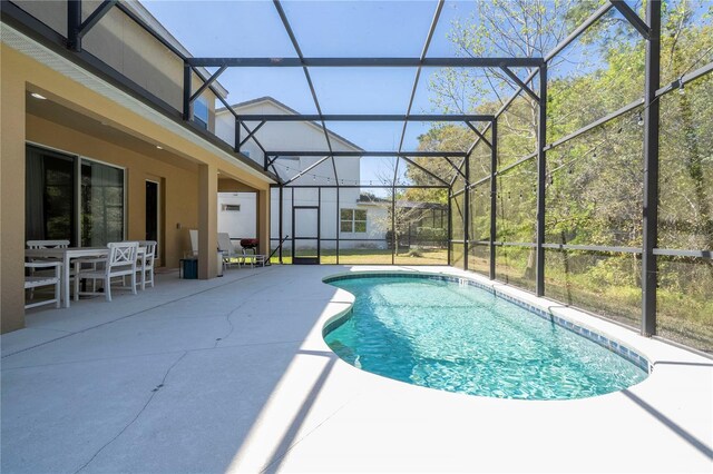 pool featuring a patio area, glass enclosure, and outdoor dining area