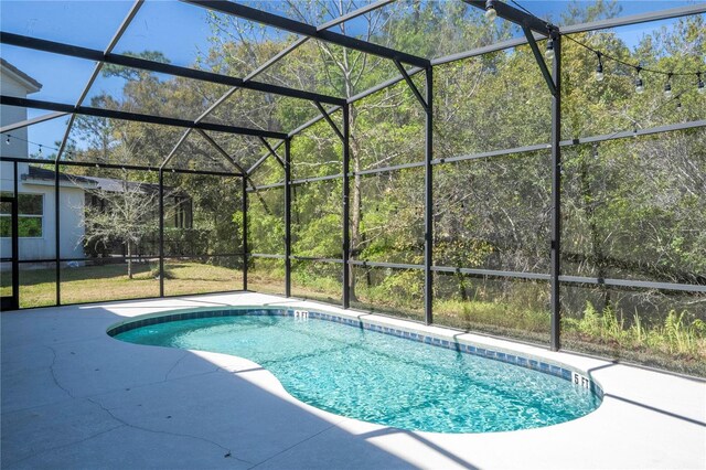 outdoor pool featuring glass enclosure and a patio area