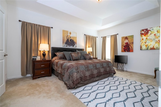bedroom with a tray ceiling, baseboards, and light colored carpet