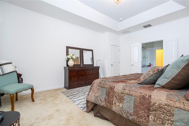 carpeted bedroom featuring a raised ceiling, baseboards, and visible vents