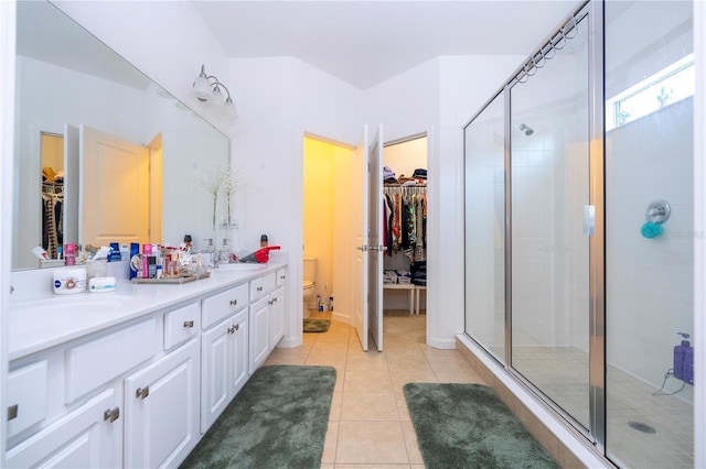 full bath with tile patterned flooring, toilet, a stall shower, and a sink