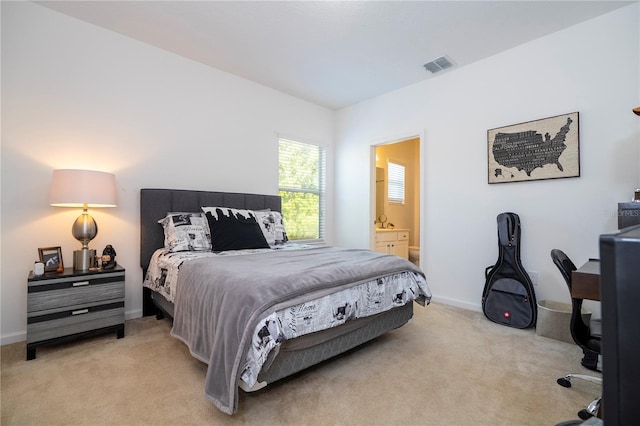bedroom with light carpet, visible vents, connected bathroom, and baseboards