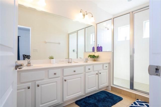full bath with double vanity, a stall shower, tile patterned floors, and a sink