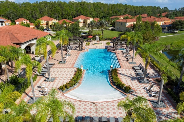 community pool with a patio, stairway, and fence