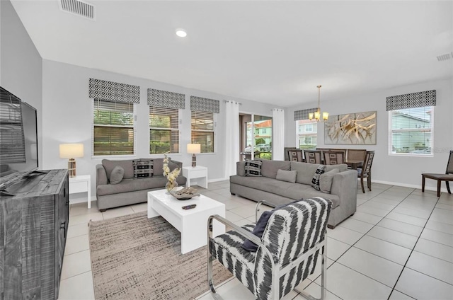 living room featuring light tile patterned floors, baseboards, visible vents, and a chandelier