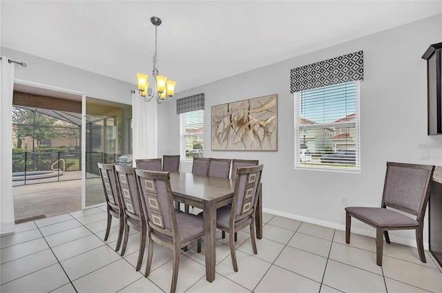 dining area featuring a chandelier, baseboards, and light tile patterned flooring