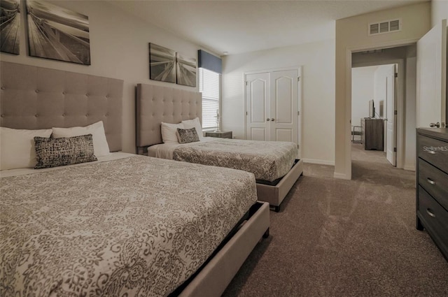 carpeted bedroom with a closet, visible vents, and baseboards