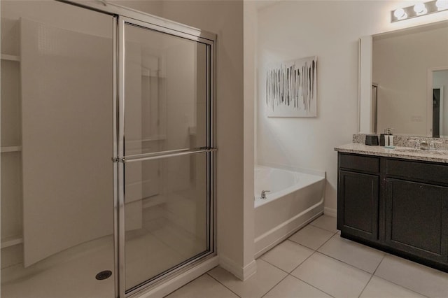 bathroom with tile patterned floors, a garden tub, a shower stall, baseboards, and vanity