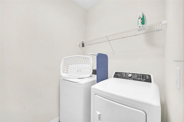 laundry area featuring laundry area, washing machine and dryer, and baseboards