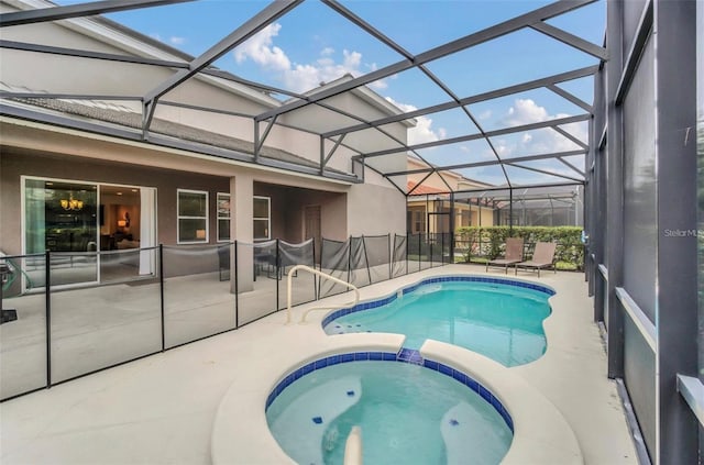 view of swimming pool with glass enclosure, a patio, and a pool with connected hot tub