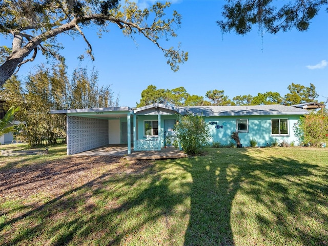 view of front of property featuring stucco siding, a carport, and a front lawn