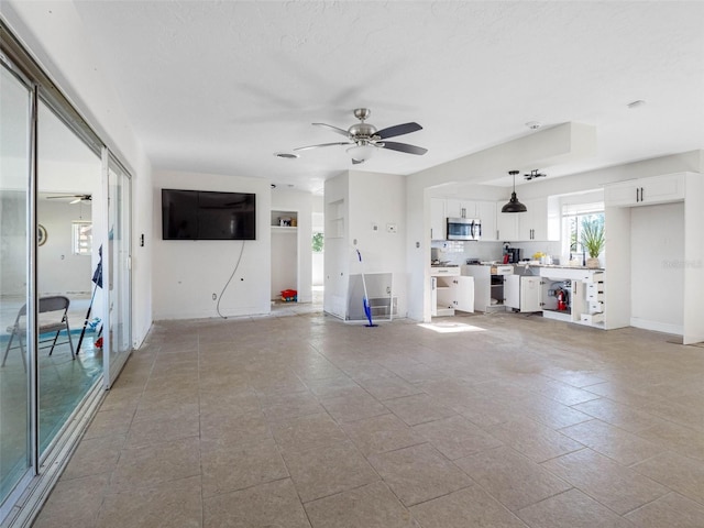 unfurnished living room with a ceiling fan