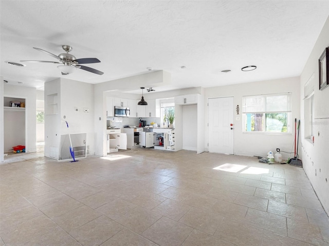 unfurnished living room with ceiling fan