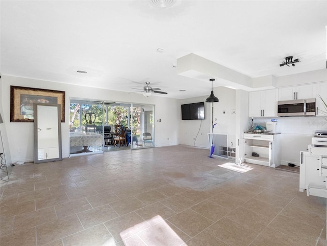 unfurnished living room featuring a ceiling fan