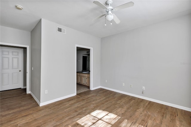 unfurnished room with visible vents, baseboards, wood finished floors, and a ceiling fan