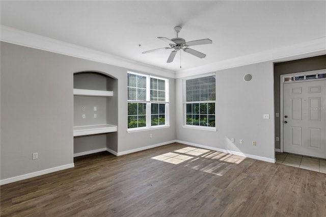 unfurnished living room with crown molding, wood finished floors, baseboards, and ceiling fan