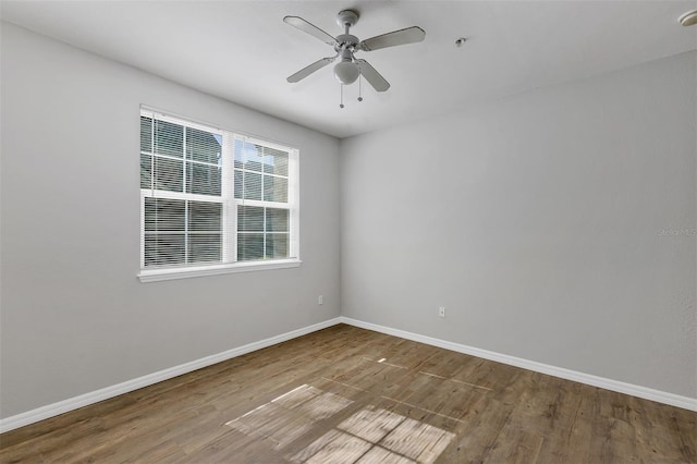 spare room with wood finished floors, baseboards, and ceiling fan