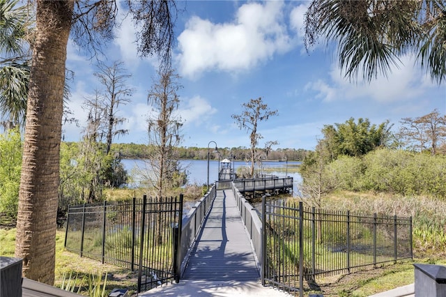 dock area with a water view and fence