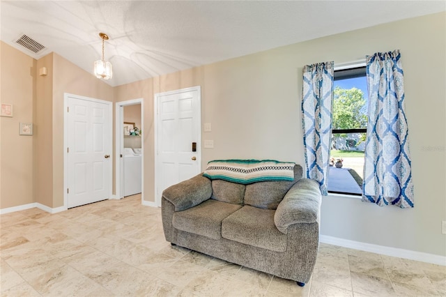 living area featuring baseboards, visible vents, and washing machine and clothes dryer