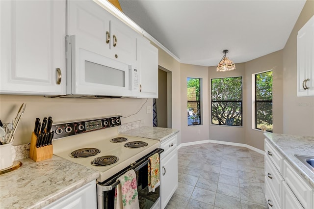 kitchen featuring white appliances, white cabinets, light countertops, and baseboards