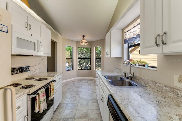 kitchen with a healthy amount of sunlight, white appliances, white cabinetry, and a sink