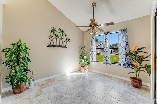 unfurnished room featuring vaulted ceiling, a ceiling fan, and baseboards